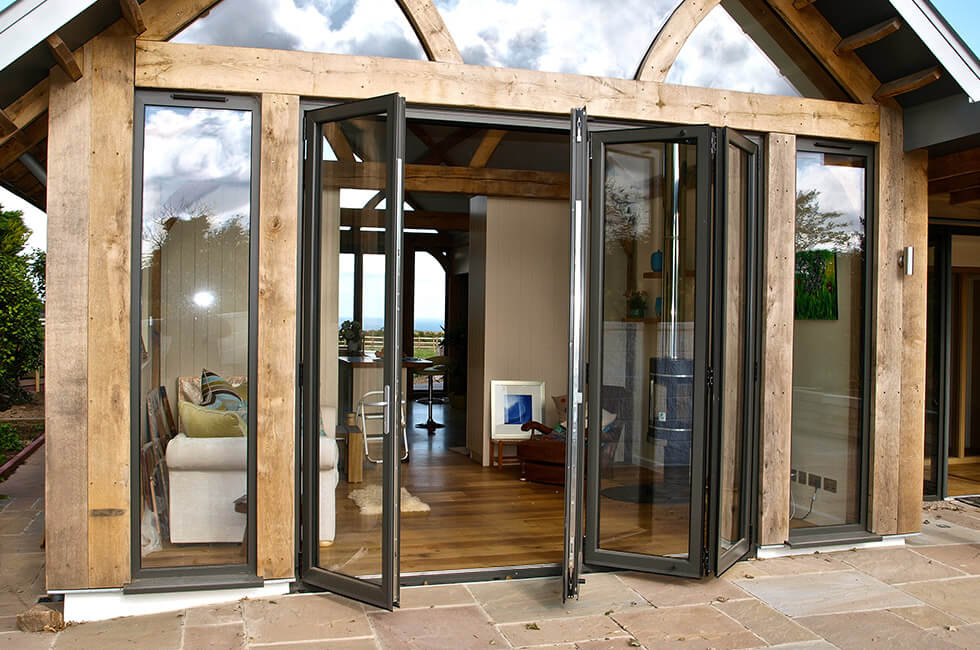 Black aluminium bifold doors on a timber extension